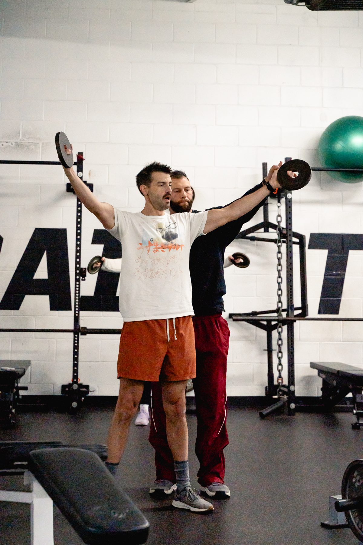A TSF coach guiding an adult member through a movement in Raleigh