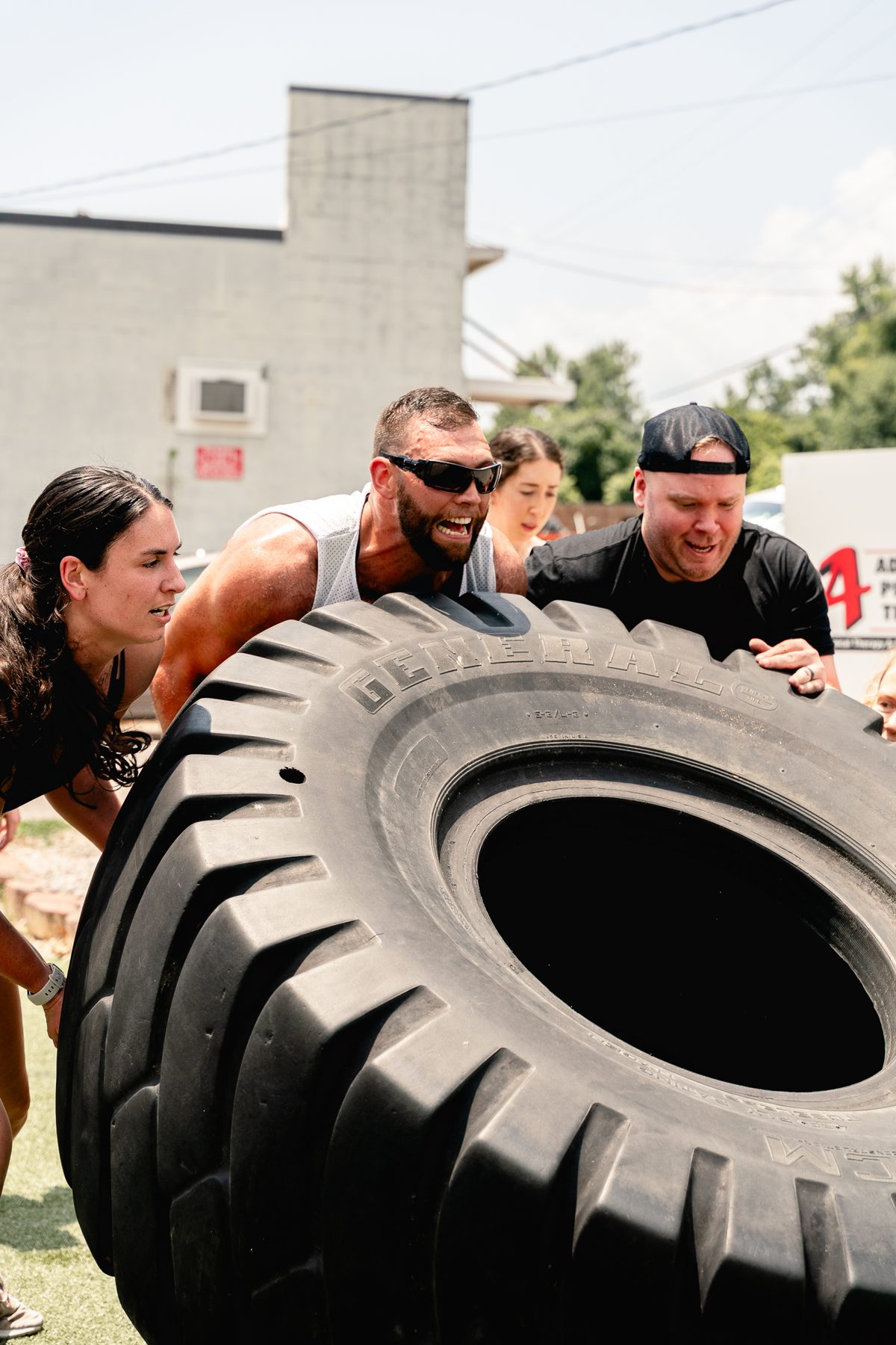 Adult member flipping a tire during a workout at The Strength Feed