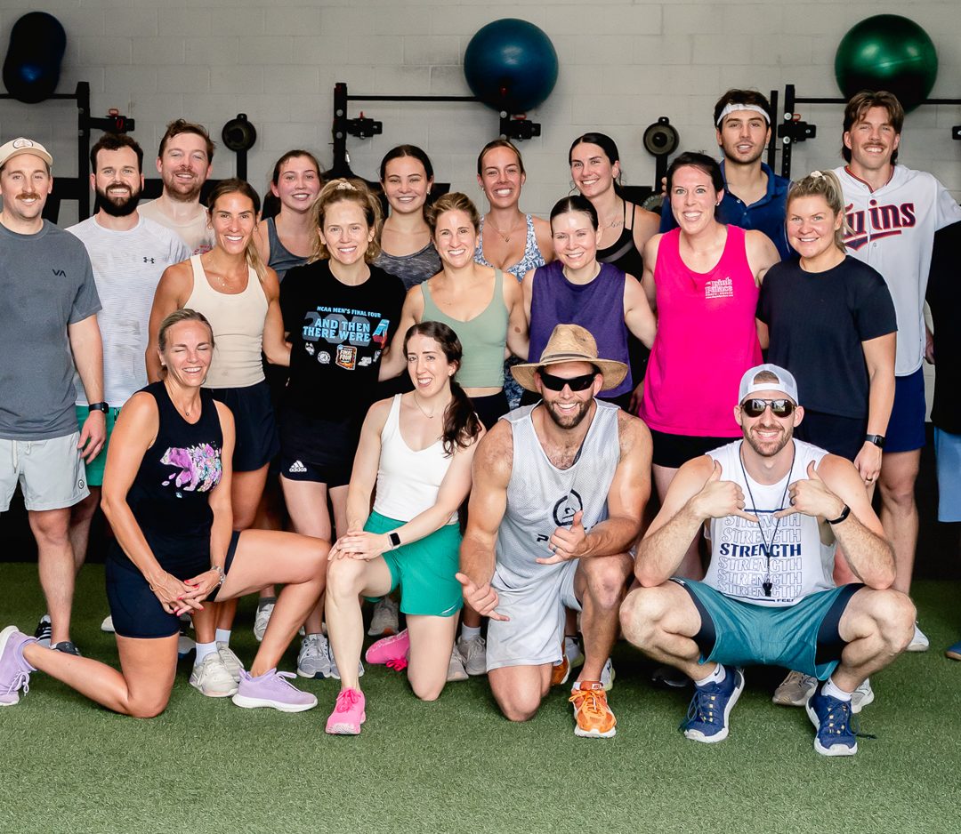 Adult members of The Strength Feed gathered together in their Raleigh gym
