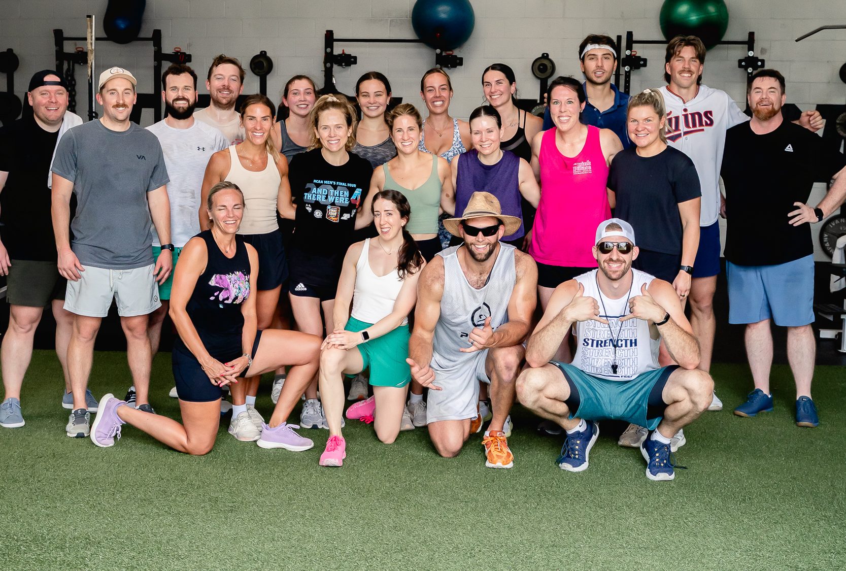 Adult members of The Strength Feed gathered together in their Raleigh gym